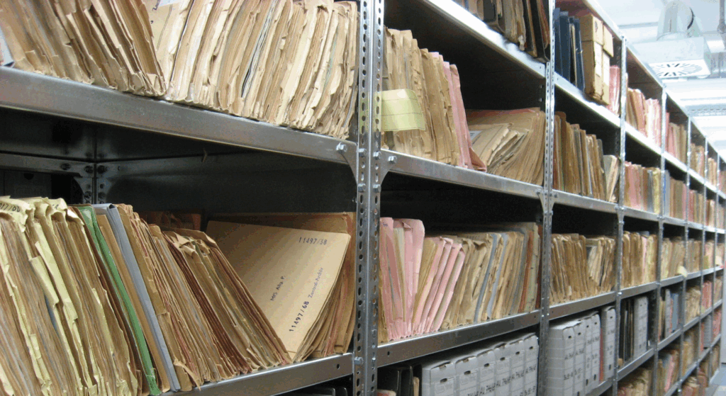 Papierakten in einem Regal: Werden Akten vernichtet, werden Metallbestandteile von Papier und Karton getrennt